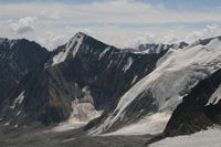 С ледника Егорова на горизонте в облаках за Алайским хребтом виден пик Ленина.